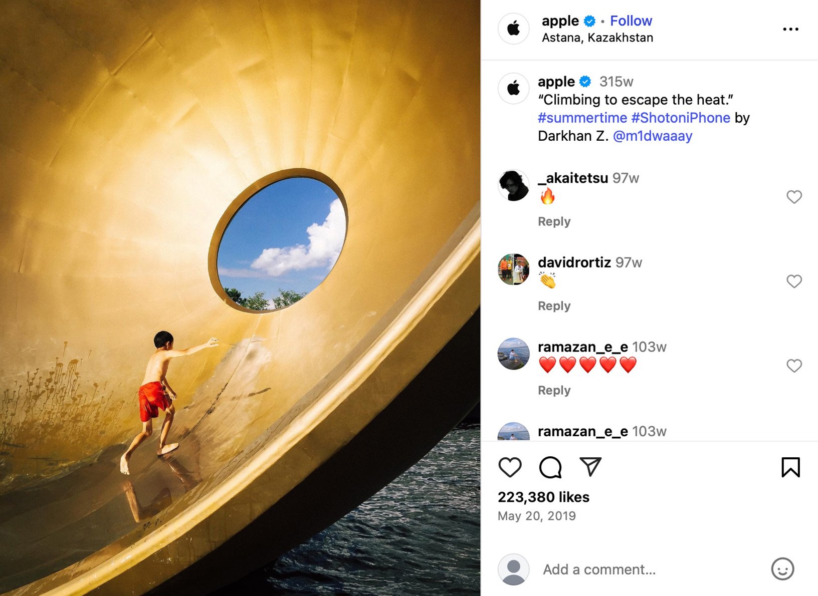 Boy climbing inside large gold sculpture with circular sky window, Astana Kazakhstan