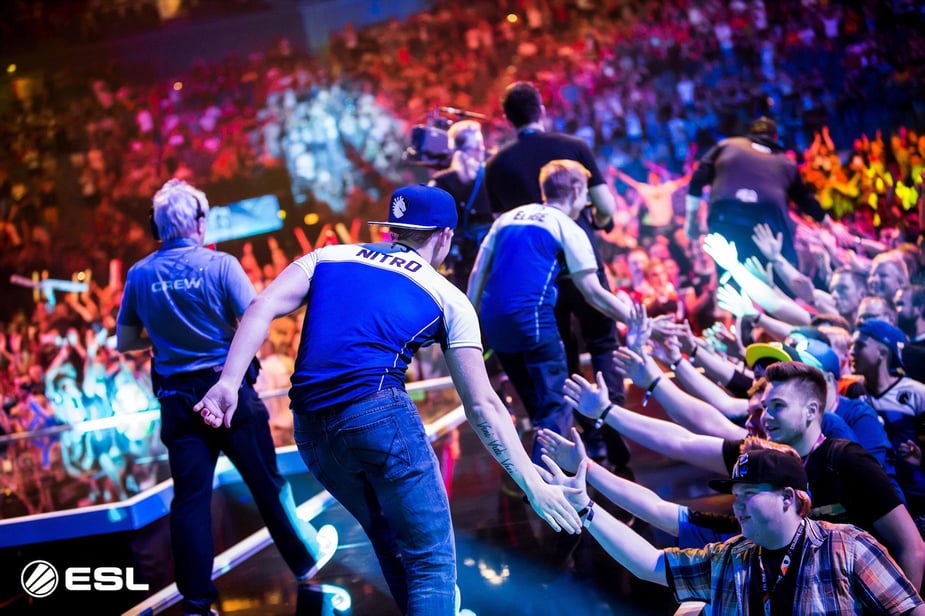 eSports team giving high fives to fans in a stadium