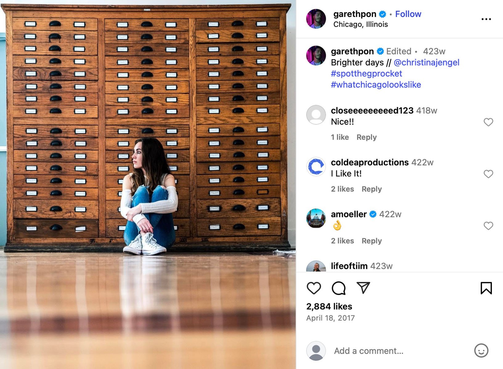 Woman sitting on the floor in front of a tall wooden cabinet with dozens of drawers