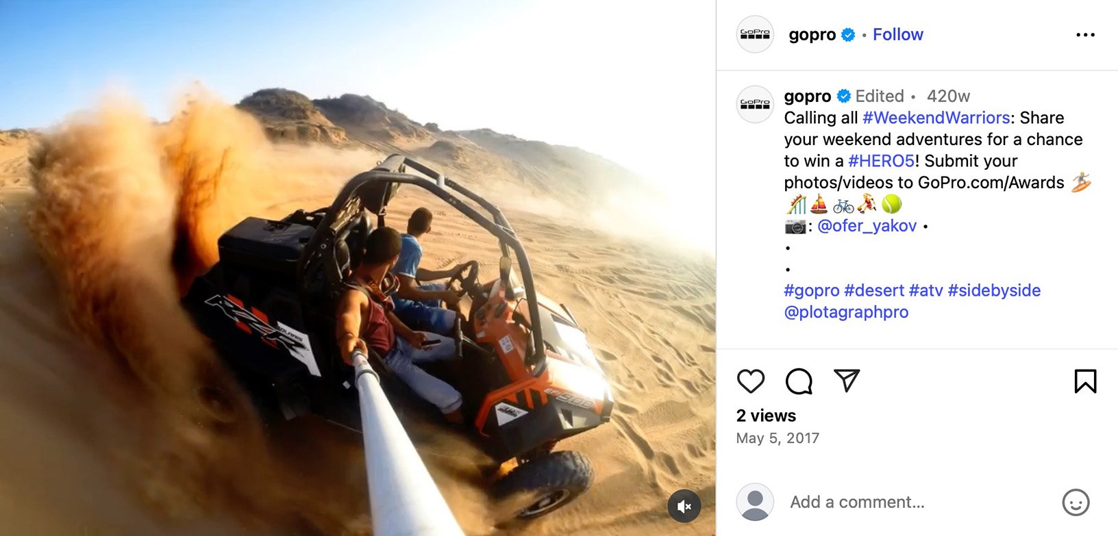Two men riding an ATV in the desert kicking up sand with a GoPro selfie stick