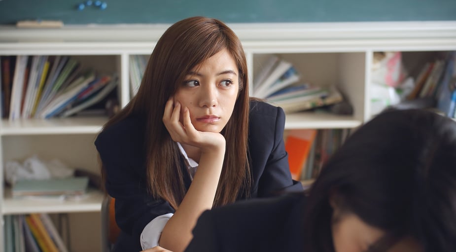 A student looking indifferent while seated in class