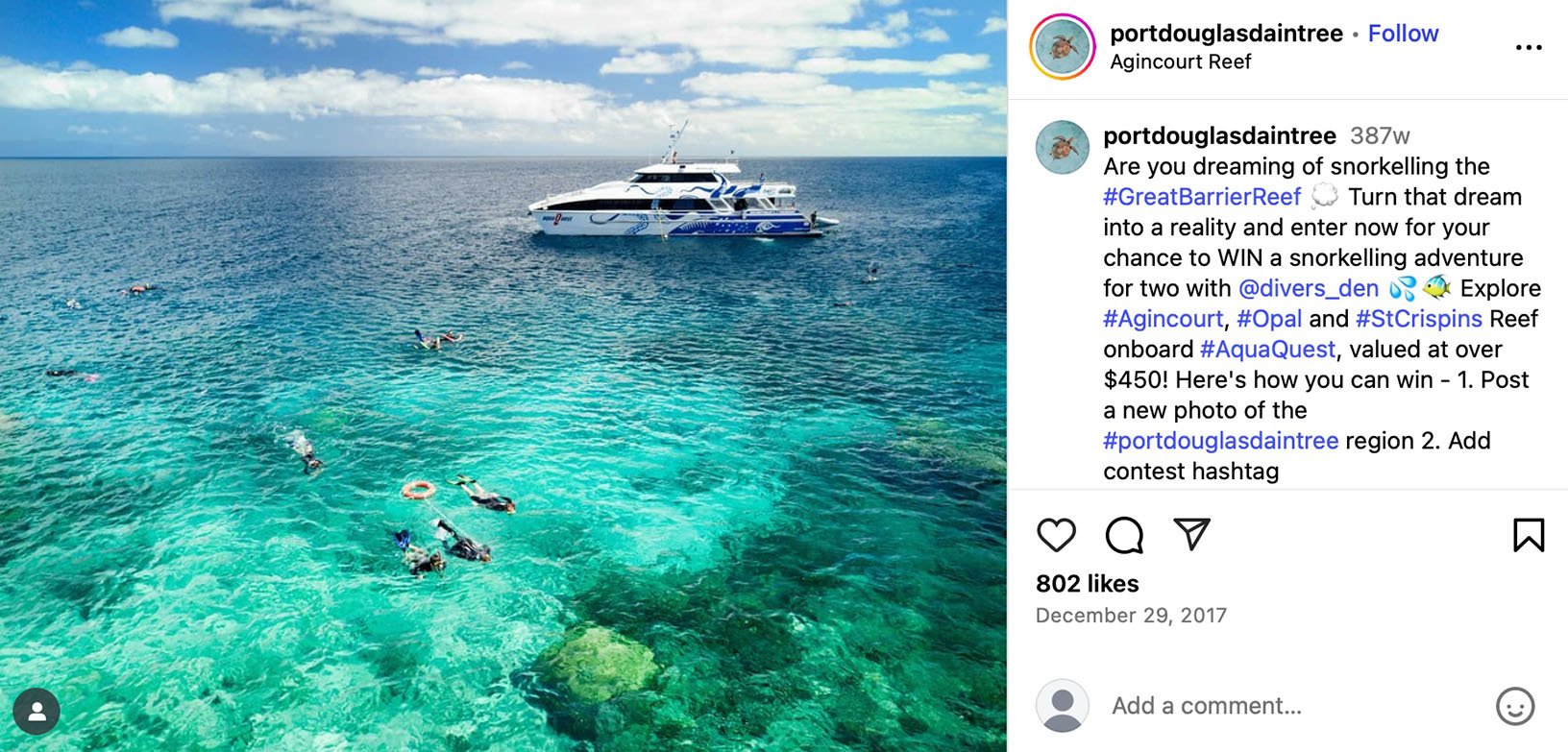 Snorkelers in clear blue Great Barrier Reef waters with AquaQuest boat in background
